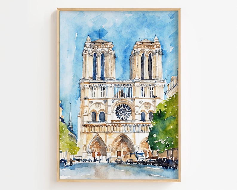 Op de afbeelding: Waterverf schilderij van de Notre Dame kathedraal in Parijs, Frankrijk. De schildering toont de voorgevel van de kathedraal met zijn twee torens, roosvenster en ingewikkelde details. De lucht is lichtblauw met wat wolken. Het schilderij is ingelijst in een licht houten lijst.
