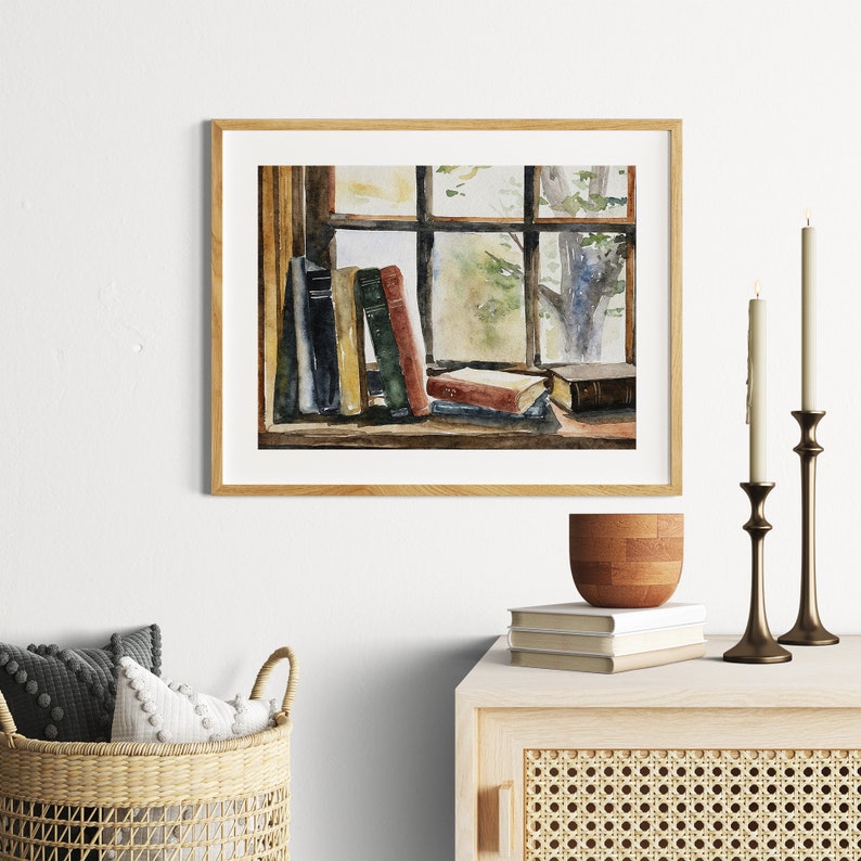 Puede incluir: Pintura acuarela de una ventana con vista a los &aacute;rboles y una pila de libros en el alf&eacute;izar de la ventana. Los libros son de varios colores, incluyendo verde, rojo y marr&oacute;n.
