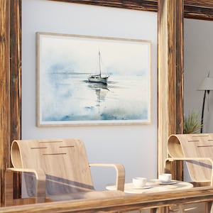 K&ouml;nnte beinhalten: Ein gerahmtes Aquarellbild eines Segelboots auf einem ruhigen Gew&auml;sser. Das Bild ist in einem hellen Holzrahmen gefasst und h&auml;ngt an einer wei&szlig;en Wand.