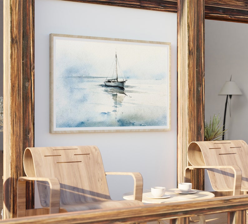 K&ouml;nnte beinhalten: Ein gerahmtes Aquarellbild eines Segelboots auf einem ruhigen Gew&auml;sser. Das Bild ist in einem hellen Holzrahmen gefasst und h&auml;ngt an einer wei&szlig;en Wand.