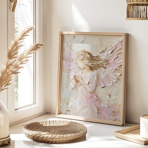 May include: A framed painting of a delicate angel with soft pink and white wings. The angel is depicted with a gentle expression and is wearing a flowing white dress. The painting is set against a light background and is framed in a simple wooden frame.