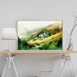 May include: Watercolor painting of a white cottage nestled in a green hillside with a winding path leading to it. The painting has a soft, dreamy feel and is framed in a silver frame.