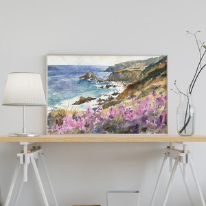 May include: Watercolor painting of a coastal landscape with a rocky coastline, blue ocean, and purple wildflowers in the foreground.