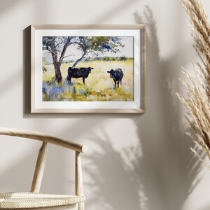 May include: Watercolour painting of two black cows in a field with a tree in the background. The cows are standing in a grassy field with blue wildflowers.