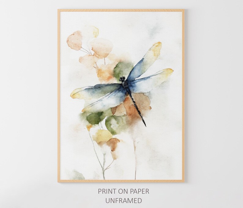May include: Watercolor print of a dragonfly with blue and yellow wings, perched on a stem with green and brown leaves. The artwork is in a wooden frame. Text at the bottom reads "PRINT ON PAPER UNFRAMED."