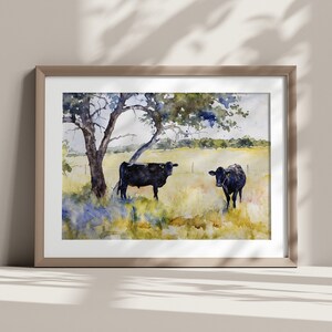 May include: Watercolour painting of two black cows standing in a field with a large tree in the background. The cows are facing each other and the field is green with blue wildflowers.