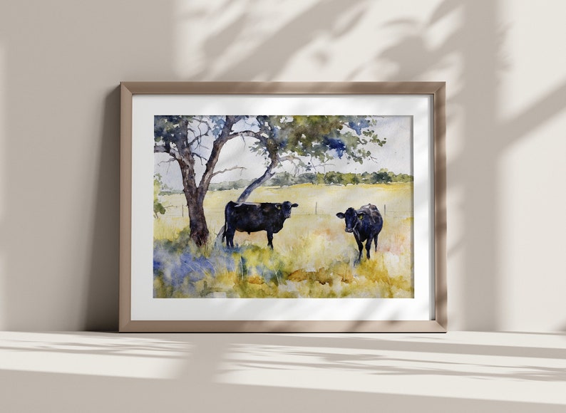 May include: Watercolour painting of two black cows standing in a field with a large tree in the background. The cows are facing each other and the field is green with blue wildflowers.