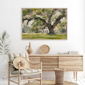 May include: Watercolor painting of a white house with a large oak tree in the front yard. The house has a porch and a green roof. The tree has large branches and green leaves. The painting is framed in a light wood frame.