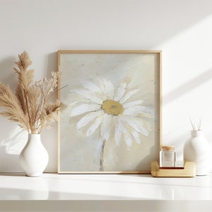 May include: A framed painting of a white daisy with a yellow center on a beige background.