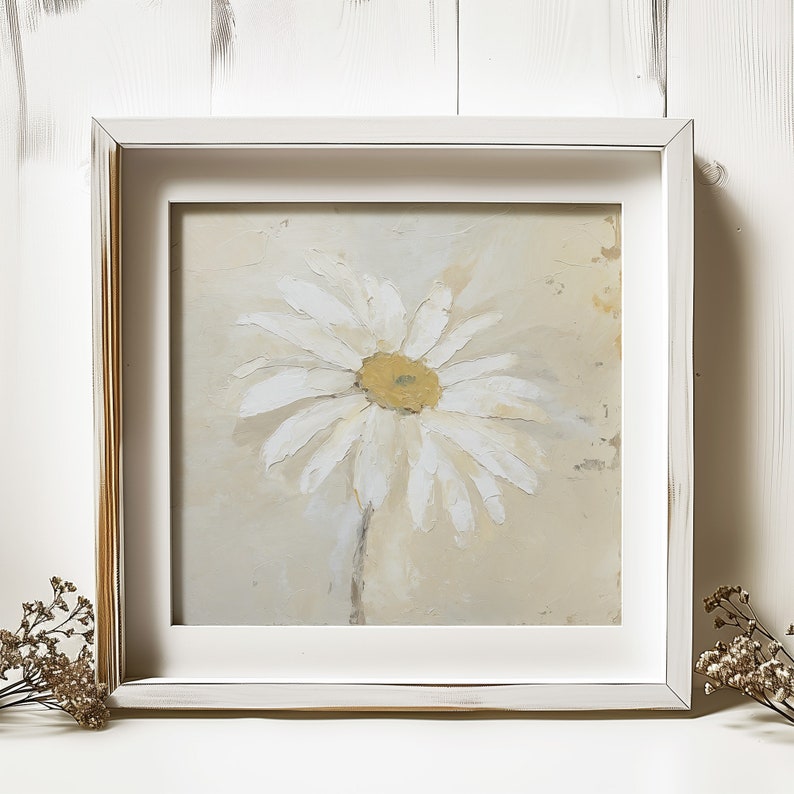 May include: A framed painting of a white daisy with a yellow center on a beige background.