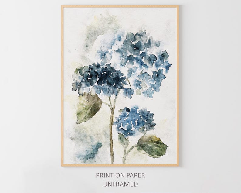 May include: A watercolor painting of blue hydrangeas with green leaves on a white background. The painting is framed in a light wood frame.
