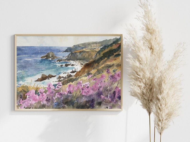 May include: Watercolor painting of a coastal landscape with a rocky shoreline, blue ocean, and a hillside covered in purple wildflowers.