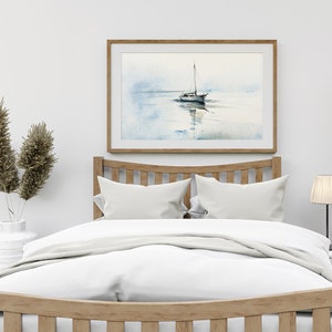 K&ouml;nnte beinhalten: Ein wei&szlig;es Bett mit einem Holz-Kopfteil und einem wei&szlig;en Bettbezug. &Uuml;ber dem Bett h&auml;ngt ein gerahmtes Aquarellbild eines Segelboots. Links neben dem Bett steht eine Vase mit getrocknetem Pampasgras und rechts eine Lampe.