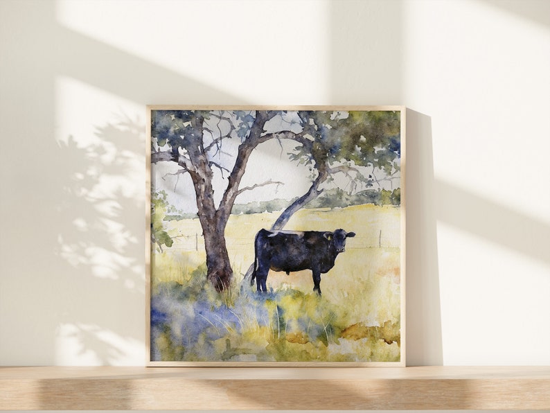 May include: Watercolour painting of a black cow standing in a field under a large tree with green leaves. The background is a soft yellow and blue.