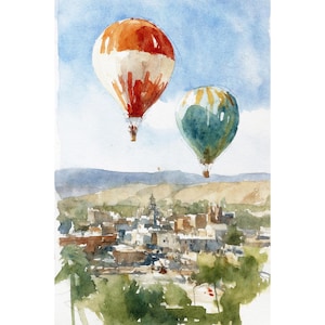 May include: Watercolour painting of two hot air balloons above a town. One balloon is orange and white, the other is teal and yellow. The town has buildings and trees, with a blue sky background.