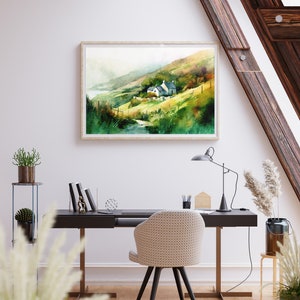 May include: A watercolor painting of a small cottage nestled in a green hillside with a winding path leading to it. The painting is framed in a light wood frame and hangs on a white wall.