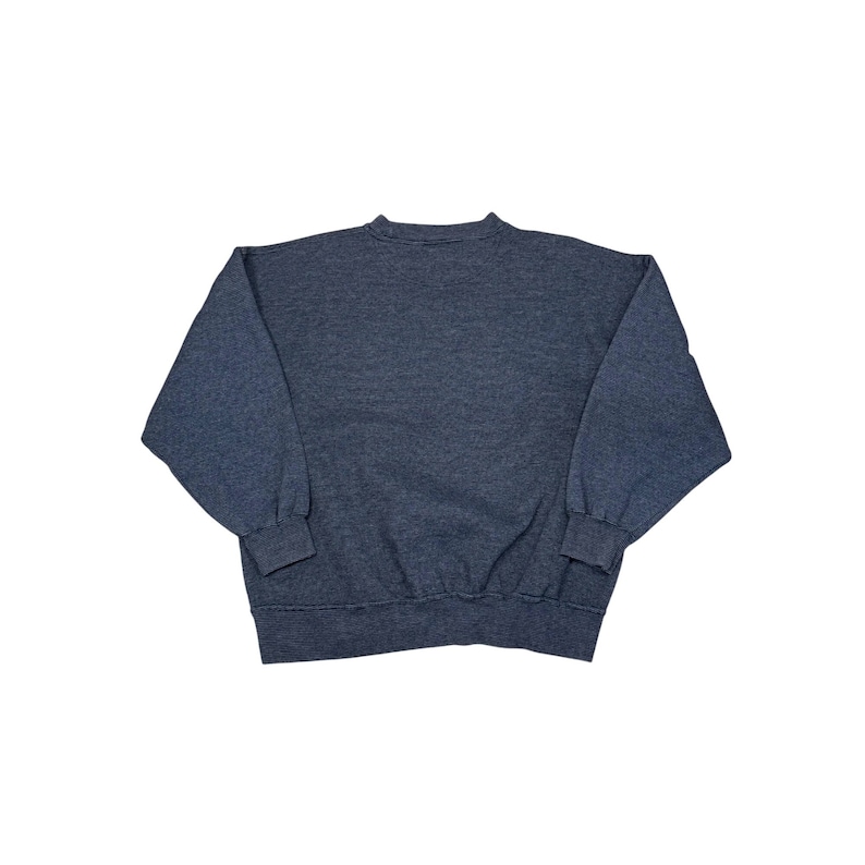 May include: A dark blue sweatshirt with long sleeves. The sweatshirt is made of a soft material and has a crew neck. The sleeves have ribbed cuffs. The garment is laid flat on a white surface.
