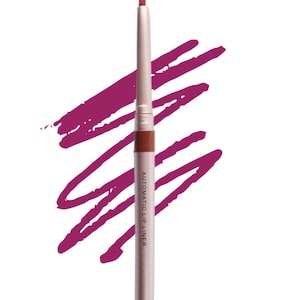 Op de afbeelding: Een zilveren automatische lipliner met de tekst "AUTOMATIC LIP LINER" erop gedrukt. De lipliner is tegen een witte achtergrond met een roze veeg kleur.