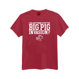 May include: Red t-shirt with white text that reads "Can anything stop the BIG PIG INVASION?" and a white cartoon pig illustration.