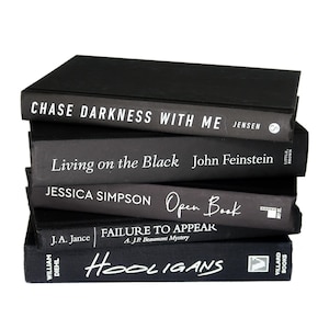 May include: A stack of five black hardcover books with white text titles. The titles are "Chase Darkness With Me", "Living on the Black", "Open Book", "Failure to Appear", and "Hooligans".