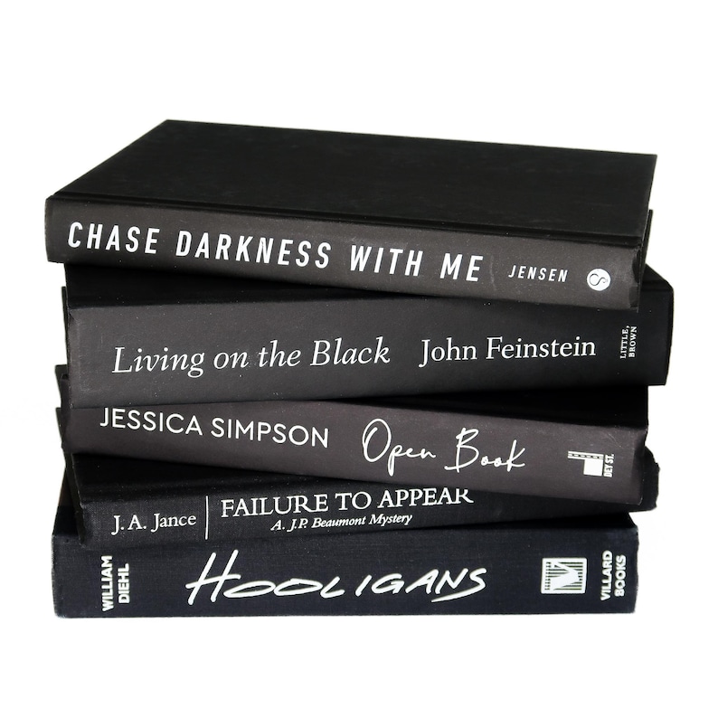 May include: A stack of five black hardcover books with white text titles. The titles are "Chase Darkness With Me", "Living on the Black", "Open Book", "Failure to Appear", and "Hooligans".