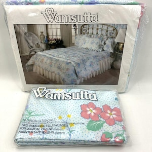 Puede incluir: Juego de cama Wamsutta Dahlia en embalaje de plástico. El juego incluye dos fundas de almohada estándar para almohadas de 50x66 cm, con un tamaño final de 50x76 cm. La tela presenta un patrón de puntos azul claro con flores rosas y amarillas.