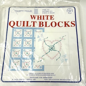 Puede incluir: Bloques de edredón blancos con borde azul, con diseños de bordado de corazones y pájaros. El paquete incluye el texto "WHITE QUILT BLOCKS" y "BIRDS & HEART". Fabricado con tela de poliéster/algodón 50/50.