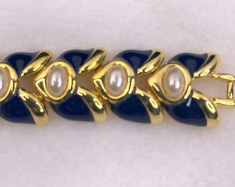 May include: A gold and blue bracelet with faux pearls. The bracelet has a clasp closure.