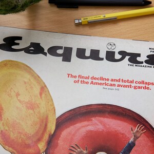 May include: A vintage magazine cover for Esquire magazine, featuring a red and yellow illustration of a person's hand reaching up from a large red circle. The cover text reads "Esquire" in bold black letters and "The final decline and total collapse of the American avant-garde. See page 142." The magazine cover is dated May 1969 and the price is $1.