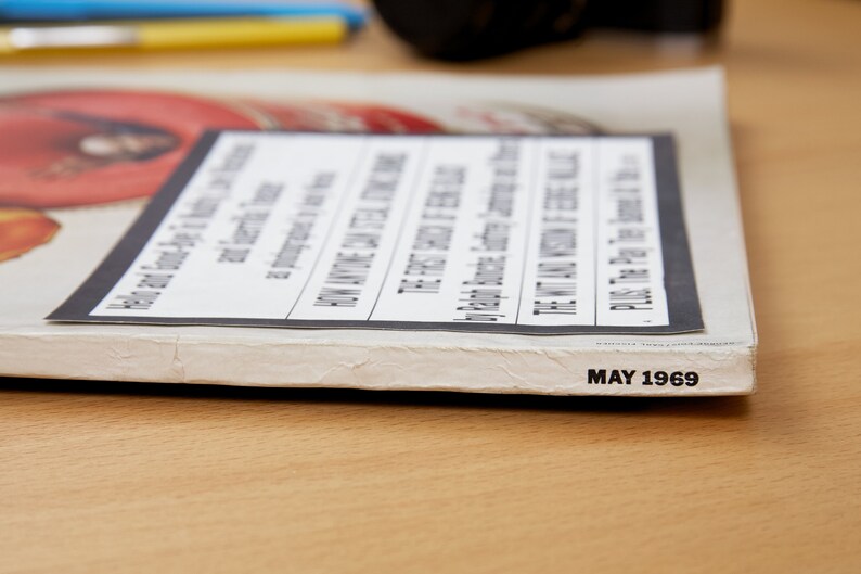 May include: Close-up of the spine of a magazine with the text "MAY 1969" printed on the bottom edge. The magazine cover is white with a black and white image of a woman's face.