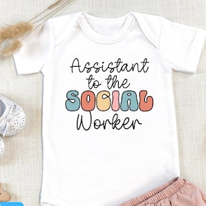 May include: White baby onesie with the text "Assistant to the Social Worker" in colorful retro font.
