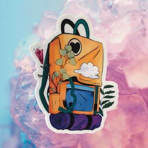 May include: A yellow and blue backpack with a heart on the front, a cloud, and green leaves. The backpack has a purple sleeping bag rolled up at the bottom.