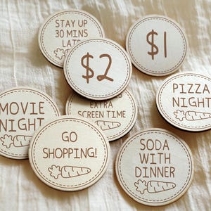 May include: Eight wooden tokens with different rewards written on them. The rewards include "Movie Night", "Pizza Night", "Go Shopping", "Soda with Dinner", "Stay Up 30 Mins Late", "Extra Screen Time", "£1", and "£2".