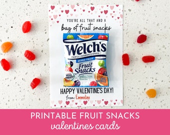 May include: A printable Valentine's Day card with a pink background and white hearts. The card says "You're all that and a bag of fruit snacks" and features a small packet of Welch's Mixed Fruit Snacks. The card also says "Happy Valentine's Day!" and "from: Emmeline".