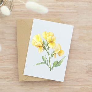 May include: A greeting card featuring a watercolor illustration of yellow flowers with green leaves. The card is on top of a brown envelope, set against a light wood grain background. The flowers have a delicate, detailed appearance.
