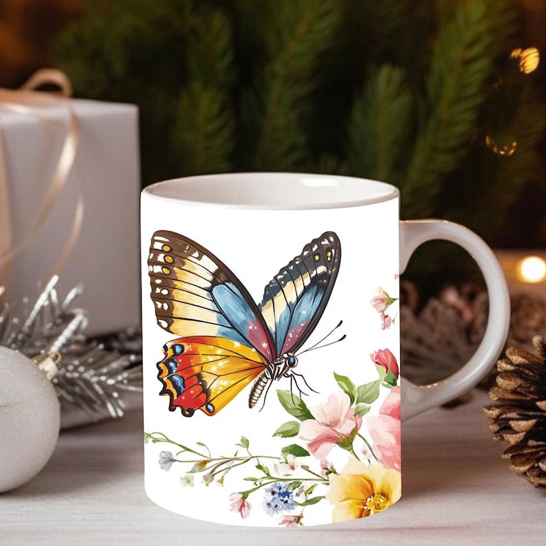 May include: White ceramic mug with a colorful butterfly design and floral accents. The butterfly has yellow, red, blue, and brown wings. The flowers are pink, yellow, and blue.