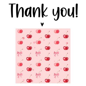 K&ouml;nnte beinhalten: Ein rosa Hintergrund mit einem Muster aus roten Kirschen und rosa Schleifen. Die Worte "Thank you!" sind in schwarzer Schrift &uuml;ber dem Muster geschrieben, mit einem kleinen schwarzen Herz darunter.