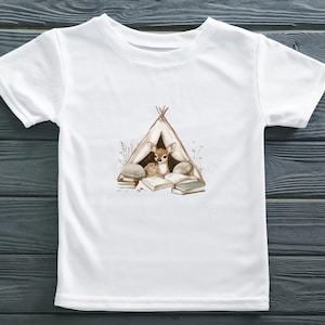 May include: White t-shirt with a brown deer reading a book inside a teepee. The teepee is surrounded by rocks and flowers.