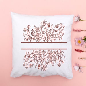 May include: White pillow with a brown outline of a floral design. The design features a row of flowers at the top and a row of flowers at the bottom, with a blank space in the middle.