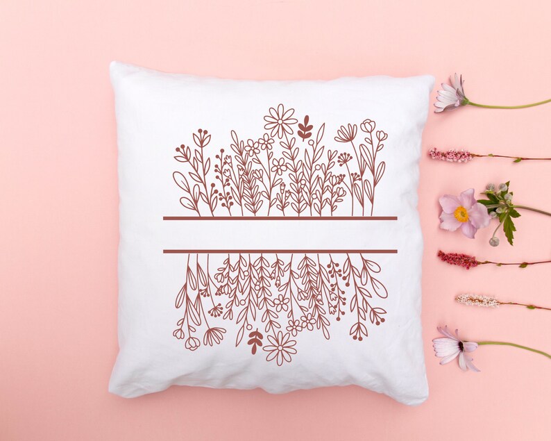 May include: White pillow with a brown outline of a floral design. The design features a row of flowers at the top and a row of flowers at the bottom, with a blank space in the middle.