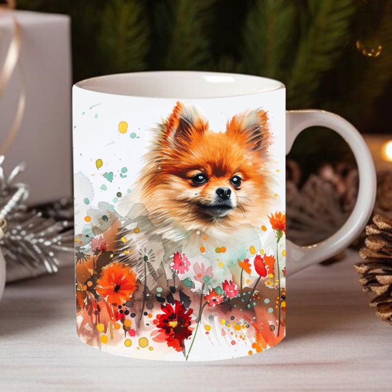 May include: White ceramic mug with a watercolor illustration of an orange Pomeranian dog surrounded by colorful flowers. The dog is looking directly at the viewer.