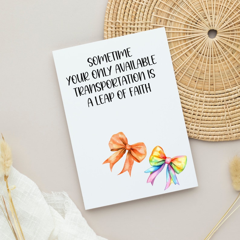 May include: A white card with the text "Sometime your only available transportation is a leap of faith."  Two watercolour bows are on the card, one orange and one rainbow.