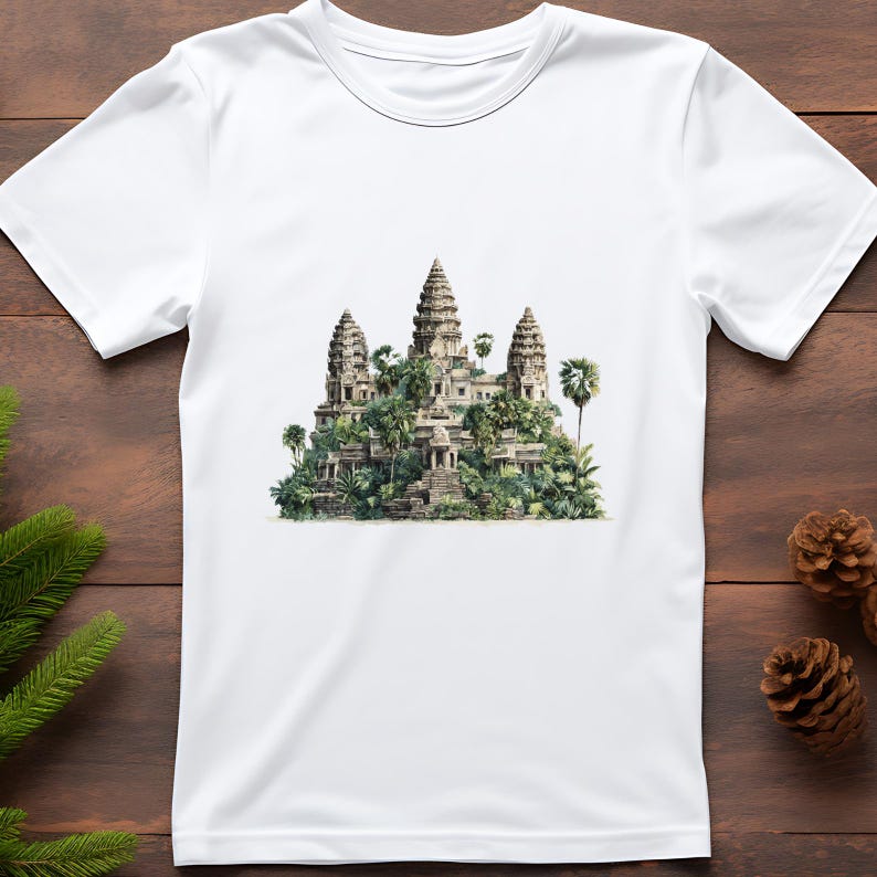 May include: White t-shirt featuring a detailed illustration of the Angkor Wat temple complex in Cambodia. The design showcases the temple's towers, surrounded by lush green foliage, creating a travel-themed graphic.