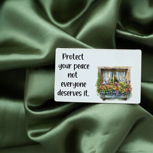 May include: A white card with the text "Protect your peace not everyone deserves it." and a picture of a window with flowers in a window box.