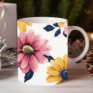 Peut inclure: Une tasse en c&eacute;ramique blanche avec un motif floral. La tasse pr&eacute;sente des fleurs roses et jaunes avec des feuilles bleu fonc&eacute; sur un fond blanc.