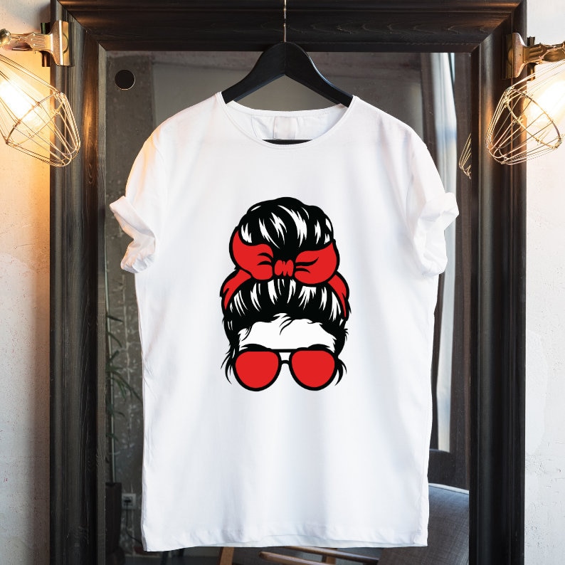 May include: White t-shirt with a black and red graphic of a woman with a messy bun and red ribbon. The woman is wearing red sunglasses.