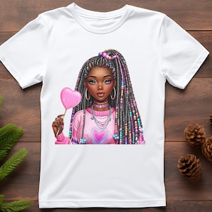 Peut inclure: T-shirt blanc avec une illustration color&eacute;e d'une femme noire aux longs cheveux tress&eacute;s, tenant une sucette rose en forme de c&oelig;ur. Elle porte un pull rose avec un motif de c&oelig;ur et des bijoux. L'&oelig;uvre est d&eacute;taill&eacute;e et vibrante.