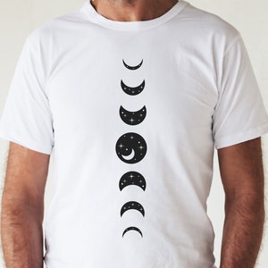 May include: White t-shirt with a black graphic of the moon phases. The moon phases are in a vertical line, starting with a crescent moon and ending with a full moon.