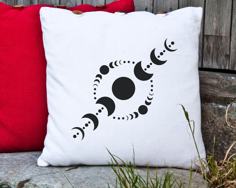 May include: White throw pillow with a black design of a circle with a large black circle in the center and a series of smaller black circles around the edge. The design is reminiscent of a moon cycle.