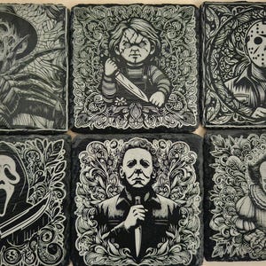 May include: Set of six black square coasters with white illustrations of horror movie characters. The characters include Freddy Krueger, Jason Voorhees, Michael Myers, Pennywise, Ghostface, and Leatherface.